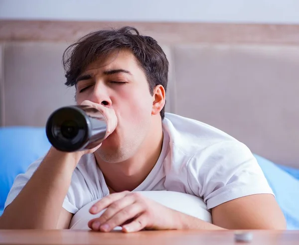 Hombre alcohólico bebiendo en la cama pasando por romper la depresión —  Fotos de Stock