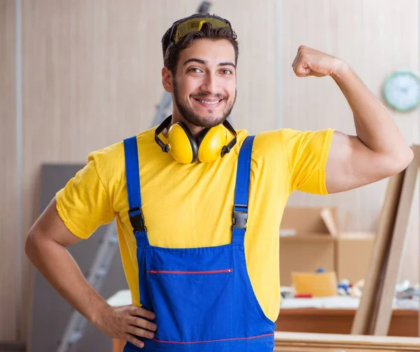 Jovem reparador carpinteiro trabalhando corte de madeira — Fotografia de Stock