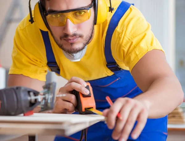 Young repairman carpenter working cutting wood on circular saw — Stock Photo, Image