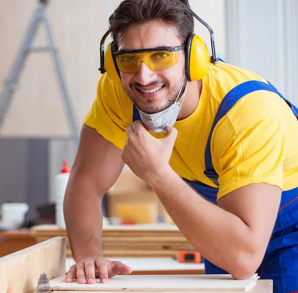 Genç bir marangoz dairesel testere ile çalışıyor. — Stok fotoğraf