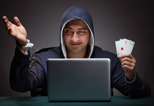 Junger Mann in Handschellen und Kapuzenpulli sitzt vor a la — Stockfoto