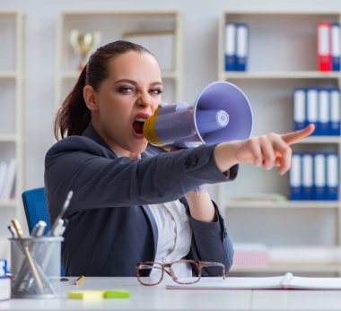 Ofiste hoparlörle bağıran kızgın iş kadını.
