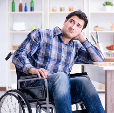 Engelli genç koca mutfakta çalışıyor.