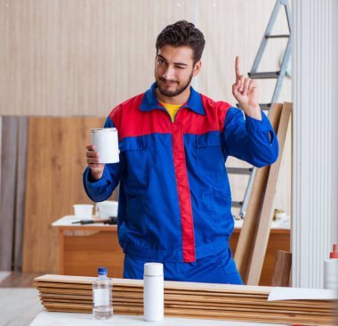 Yooung marangoz boyayla uğraşıyor.