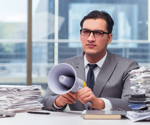 Angry businessman with loudspeaker in the office