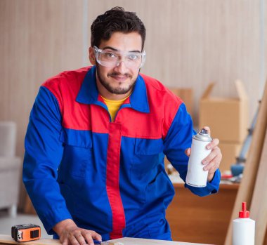 Yooung marangoz boyayla uğraşıyor.