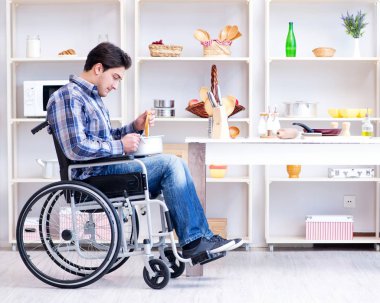 Engelli adam mutfakta çorba hazırlıyor.