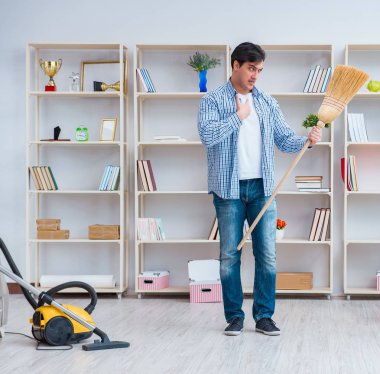 Adam evi temizliyor.