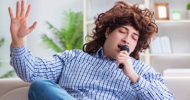 Evde karaoke yapan komik adam.
