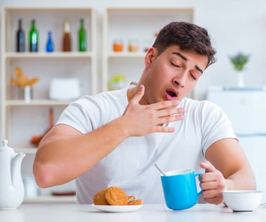 Fazla mesai sonrası kahvaltıda uyuyan bir adam.