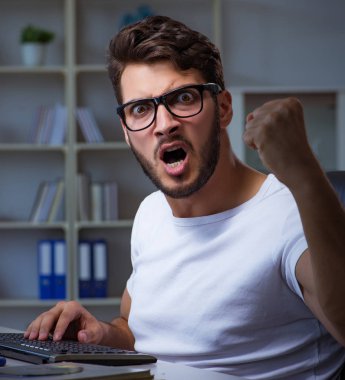 Genç adam fazla mesai yapmak için geç saatlere kadar ofiste kalıyor.