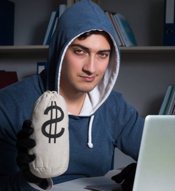 Genç hacker geceleri bilgisayarı hackliyor.
