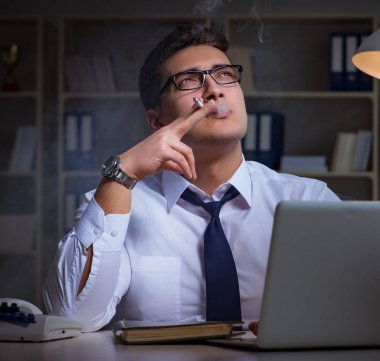 Stres altındaki iş adamı ofiste sigara içiyor