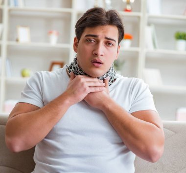 Genç adam boğaz ağrısı çekiyor.