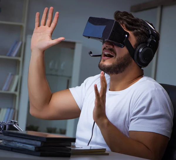 Jovem jogando jogos longas horas atrasado no escritório — Fotografia de Stock