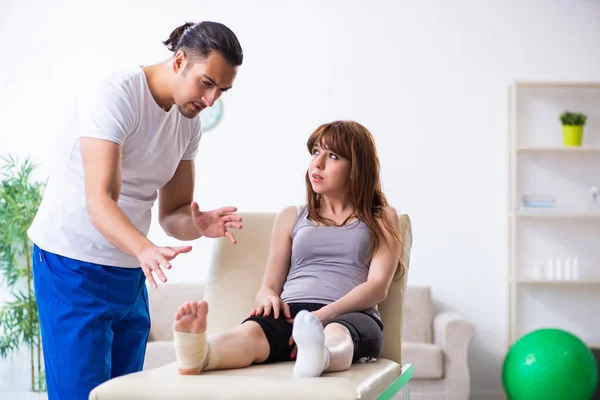 Leg injured woman visiting young doctor traumatologist — Stock Photo, Image