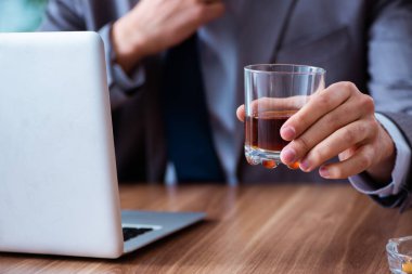 İş yerinde alkol ve sigara içen bir erkek işçi.