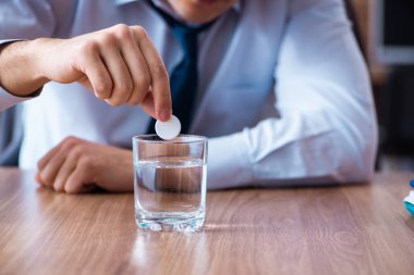 Hasta erkek çalışan ofiste acı çekiyor. 