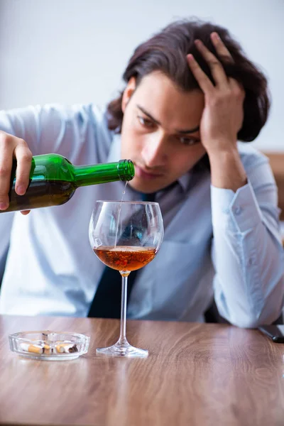 Male employee drinking alcohol and smoking cigarettes at workpla — Stock Photo, Image