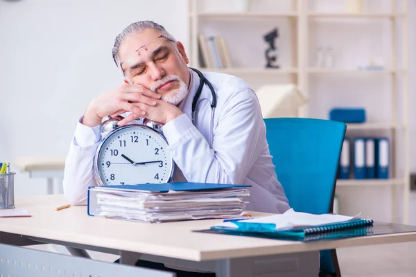 Klinikte çalışan yaşlı erkek doktor. — Stok fotoğraf