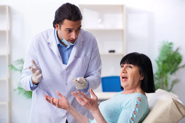 Vecchia visitando giovane medico dentista — Foto Stock