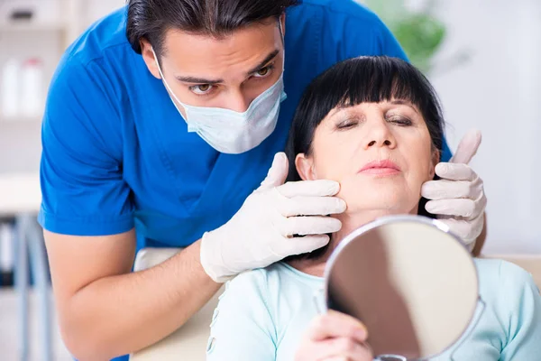 Anciana visitando a médico masculino para cirugía plástica —  Fotos de Stock