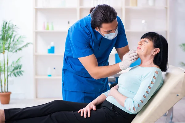 Yaşlı kadın estetik ameliyat için erkek doktoru ziyaret ediyor. — Stok fotoğraf