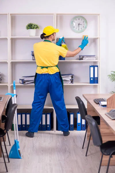 Jovem empreiteiro limpando o escritório — Fotografia de Stock