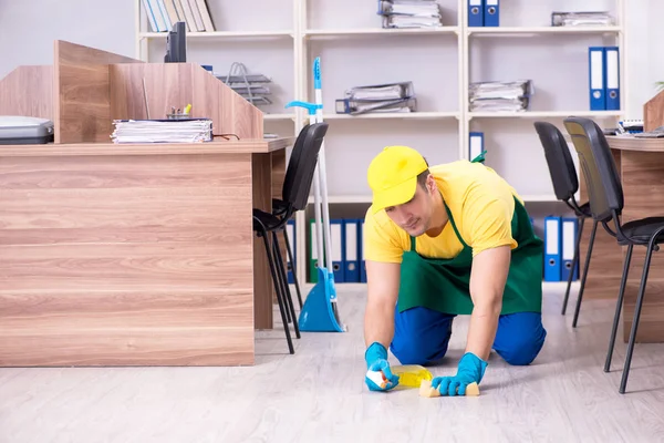 Jonge mannelijke aannemer schoonmaken van het kantoor — Stockfoto