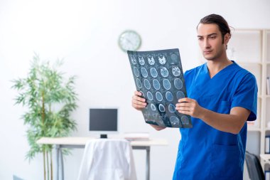 Klinikte çalışan genç erkek doktor. 