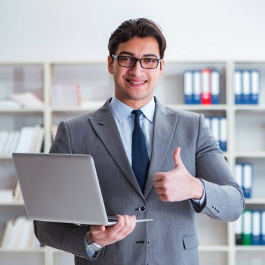 Ofisteki iş adamı dizüstü bilgisayarla çalışıyor.