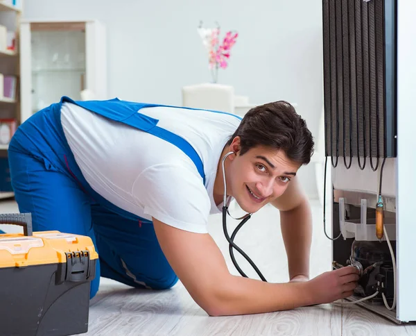 Repairman contractor repairing fridge in DIY concept