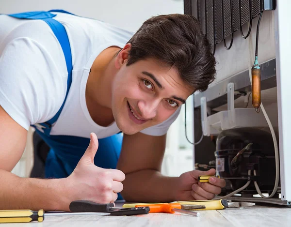 Reparatör entreprenör reparera kylskåp i DIY koncept — Stockfoto