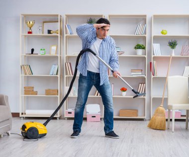 Adam evi temizliyor.