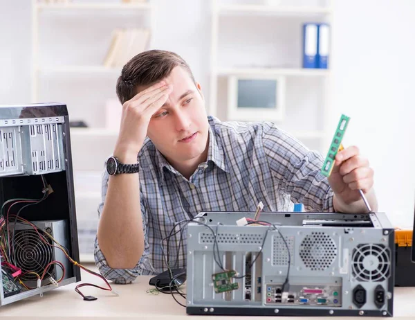 Young technician repairing computer in workshop — Stock Photo, Image