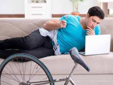 Evde bisiklet tamir eden genç bir adam.