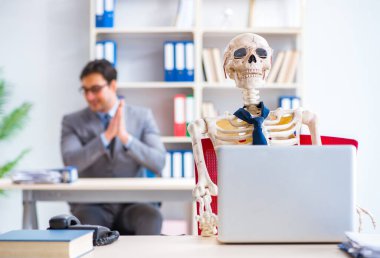 İskeletle çalışan bir iş adamı.