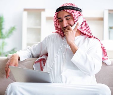 Arap adam evde çalışıyor.