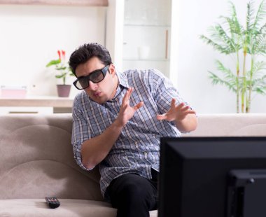 Evde 3D televizyon izleyen bir adam.