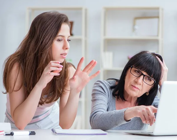 Hija explicando a mamá cómo usar la computadora — Foto de Stock