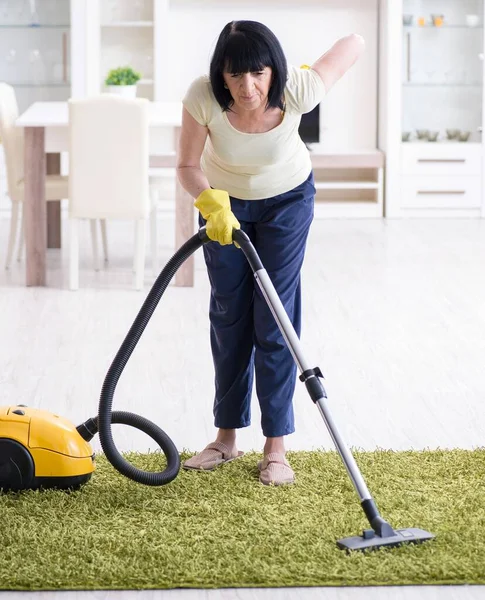 Senior old woman tired after vacuum cleaning house — Stock Photo, Image