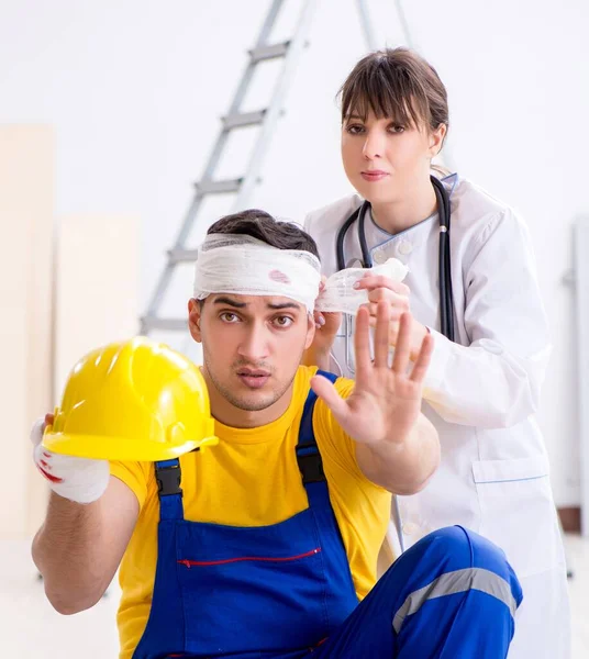 Worker with injured head and doctor — Stock Photo, Image