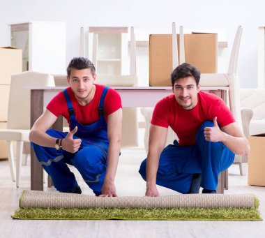 İki müteahhit personel kişisel eşyalarını taşıyor.