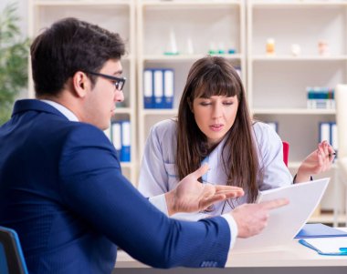 İş adamı doktorla sağlık sorunlarını tartışıyor