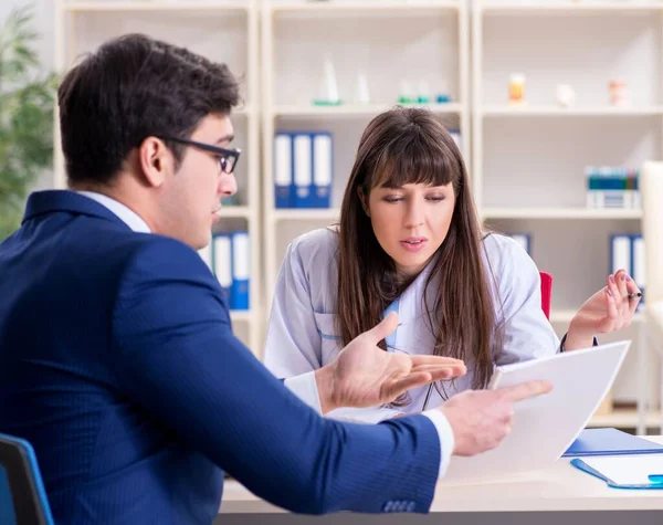 Forretningsmann diskuterer helseproblemer med lege – stockfoto