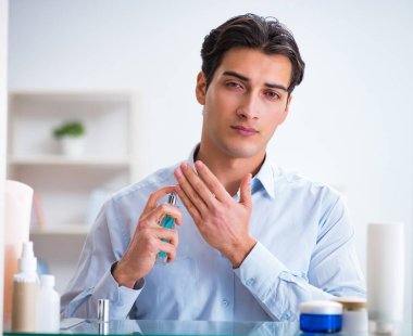 Adam banyoda çalışmak için giyiniyor.