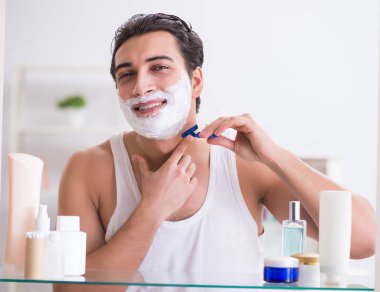 Genç yakışıklı adam sabah erkenden tıraş oluyor.