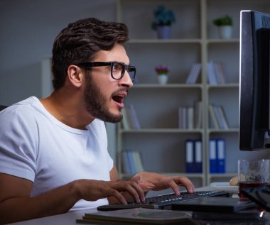 Genç adam fazla mesai yapmak için geç saatlere kadar ofiste kalıyor.