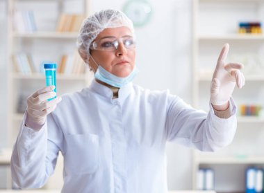 Laboratuvarda sanal düğmeye basan kadın kimyager.