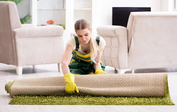 Professional female cleaner cleaning carpet